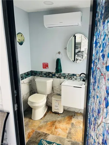 a bathroom with a toilet sink and mirror