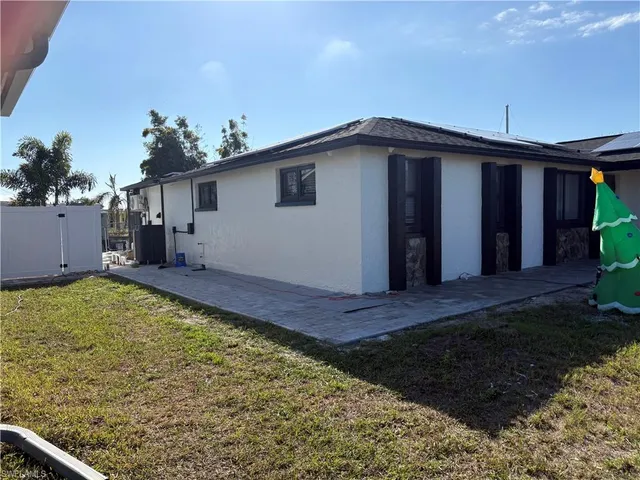 a view of a house with backyard and wooden fence