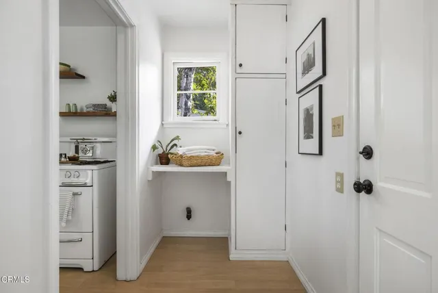 a hallway with white cabinets and chandelier