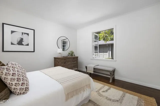 a bedroom with a bed and a lamp on dresser