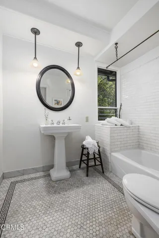 a bathroom with a sink toilet a mirror and bathtub