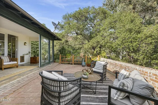a view of outdoor sitting area with furniture and wooden floor