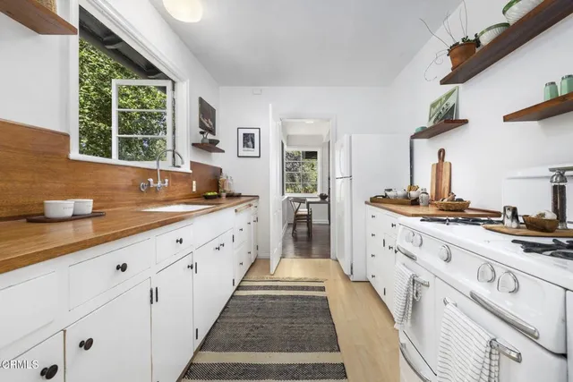a large kitchen with granite countertop a sink and a stove