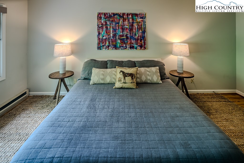 250 Fir, Unit A1 Boone, NC 28607 - Photo 18 of 31 a bedroom with a bed and a lamp