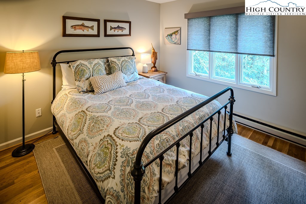 250 Fir, Unit A1 Boone, NC 28607 - Photo 21 of 31 a bedroom with a bed and wooden floor