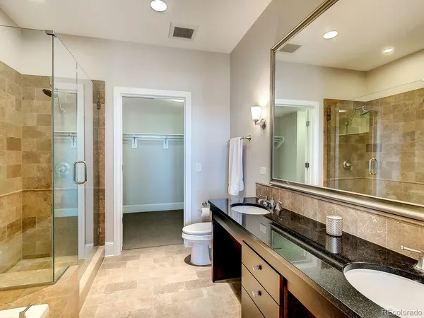 a bathroom with a double vanity sink a mirror and a shower