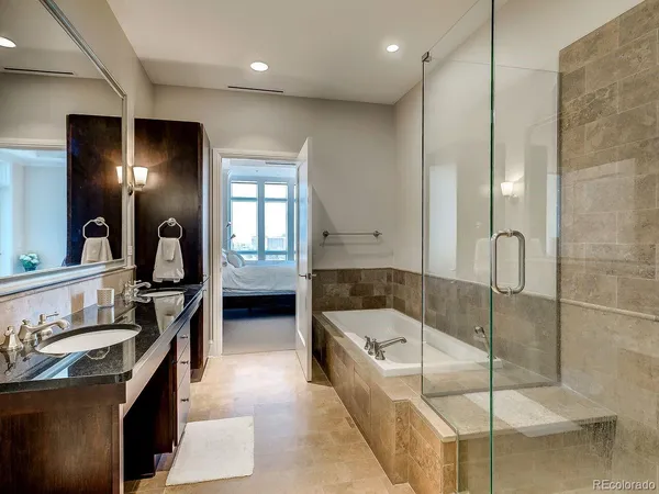 a en suite bathroom with a tub sink and mirror