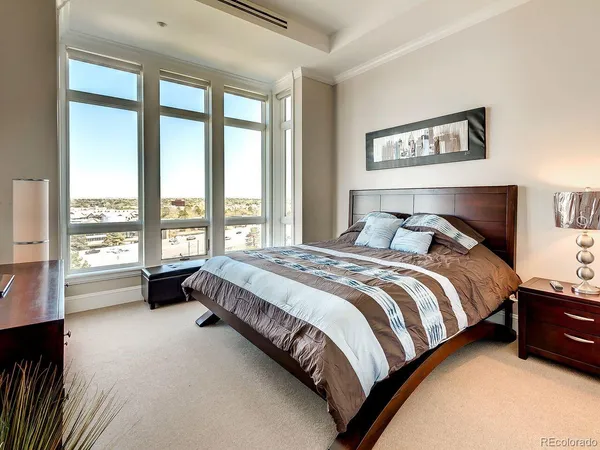 a spacious bedroom with a bed and a couch next to a window