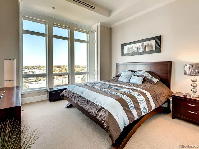 a spacious bedroom with a bed and a couch next to a window