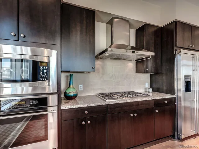 a kitchen with stainless steel appliances a stove a sink and a refrigerator