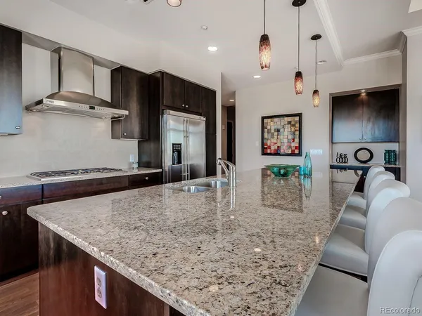 a kitchen with stainless steel appliances granite countertop a sink a refrigerator and a stove