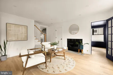 a living room with furniture a fireplace and a large mirror