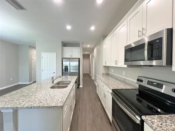 a kitchen with stainless steel appliances granite countertop a sink stove and microwave