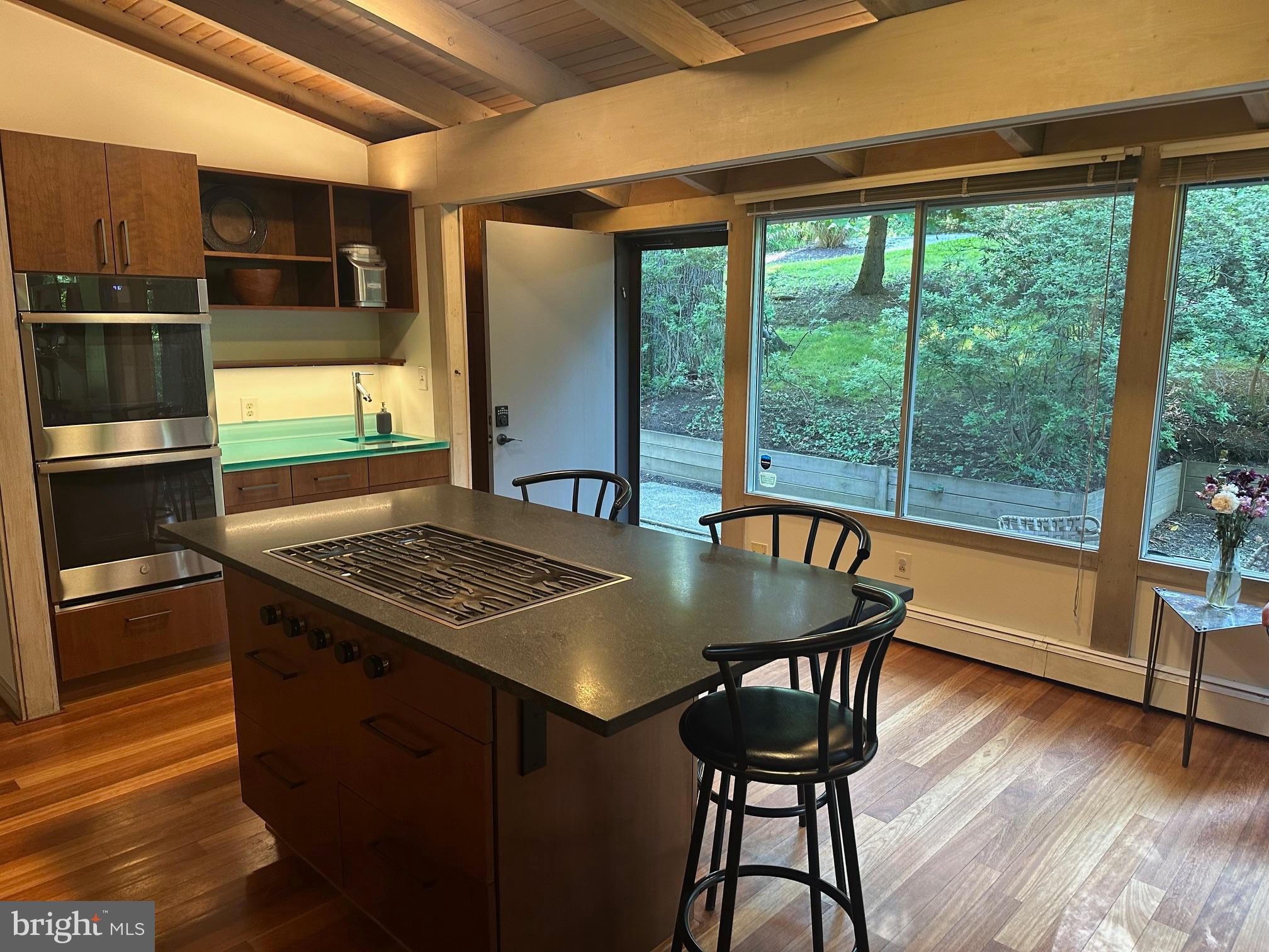 6016 The Terraces Baltimore, MD 21209 - Photo 11 of 59 a kitchen with a table chairs and wooden floor