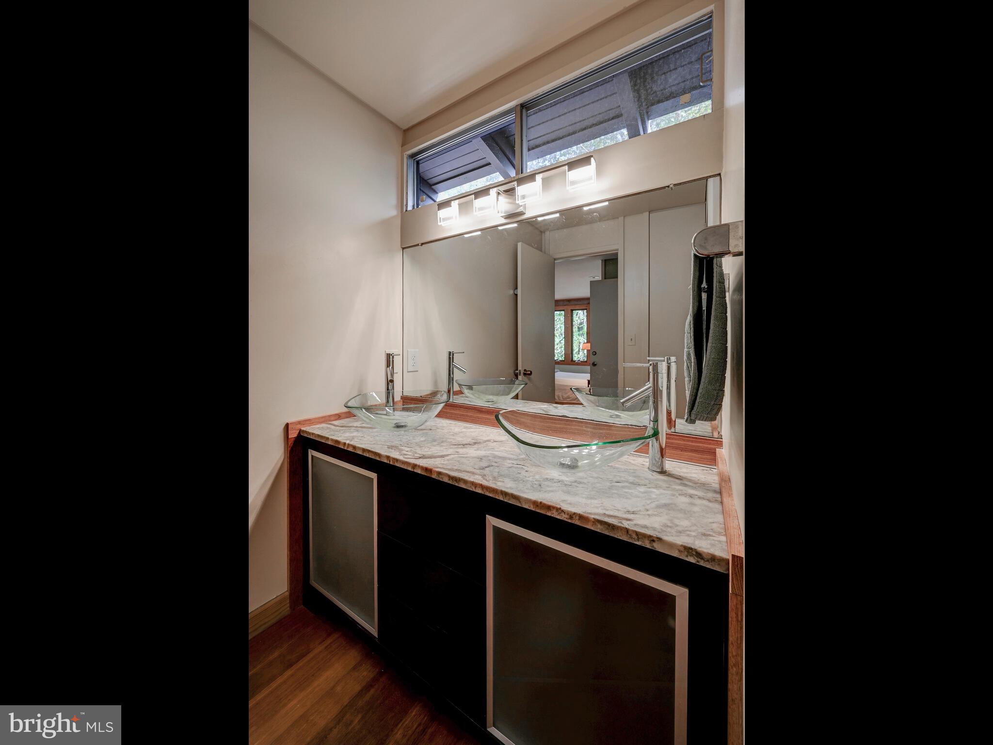 6016 The Terraces Baltimore, MD 21209 - Photo 26 of 59 a bathroom with a granite countertop sink a mirror and a vanity