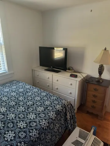 a bedroom with a bed and flat screen tv