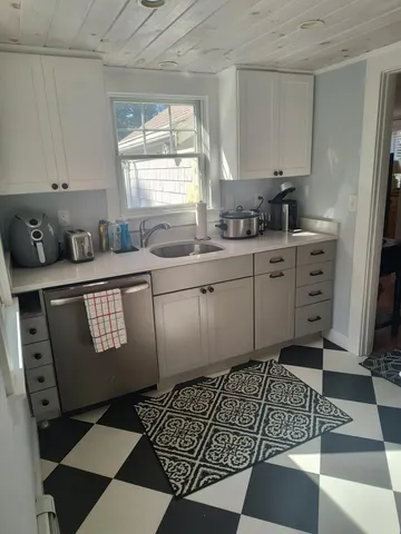 a kitchen with stainless steel appliances granite countertop a sink window and cabinets