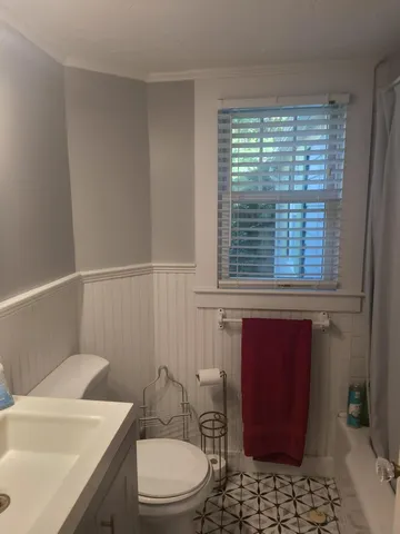 a bathroom with a toilet a sink and a window