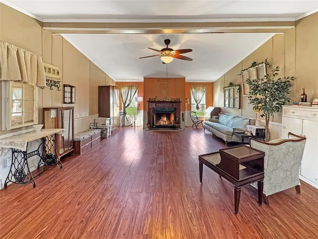 a living room with furniture a fireplace and wooden floor