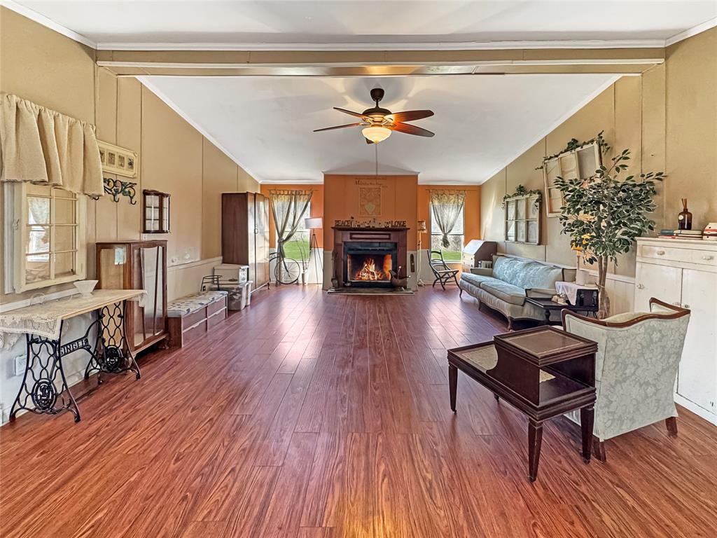 1791 County Road 3855 Poolville, TX 76487 - Photo 11 of 31 a living room with furniture a fireplace and wooden floor