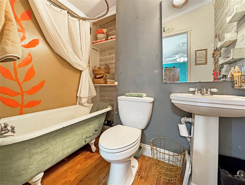 1791 County Road 3855 Poolville, TX 76487 - Photo 16 of 31 a bathroom with a toilet a sink and a bathtub