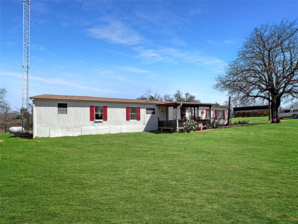 1791 County Road 3855 Poolville, TX 76487 - Photo 2 of 31 a front view of a house with a garden
