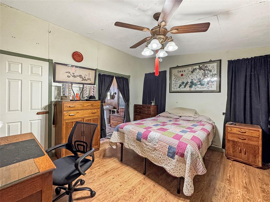 1791 County Road 3855 Poolville, TX 76487 - Photo 21 of 31 a bedroom with a bed and a chandelier