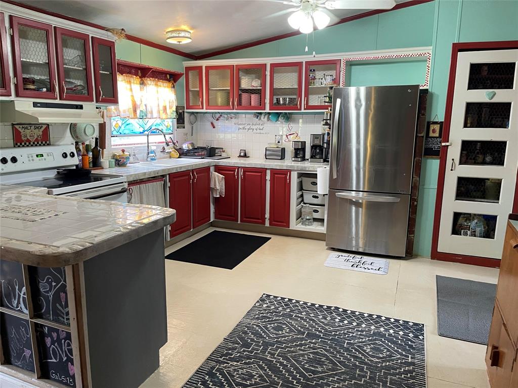 1791 County Road 3855 Poolville, TX 76487 - Photo 8 of 31 a kitchen with stainless steel appliances granite countertop a refrigerator and a sink