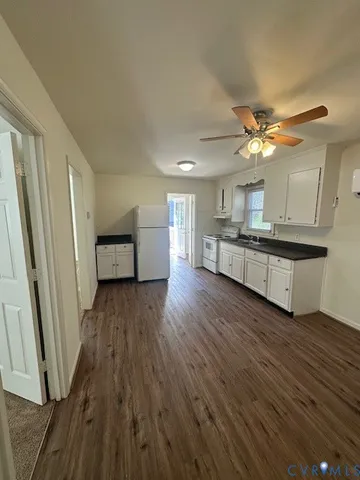 a view of a kitchen with a sink and dishwasher a refrigerator with wooden floor
