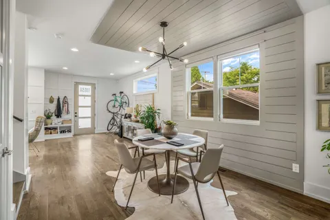 a dining room with furniture a chandelier and wooden floor