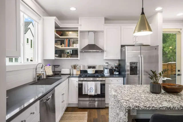 a kitchen with stainless steel appliances granite countertop a sink stove and refrigerator