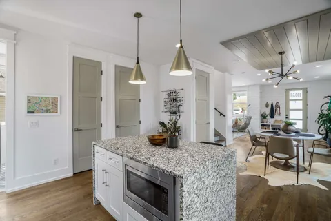 a kitchen with stainless steel appliances granite countertop furniture a stove a sink and a wooden floors