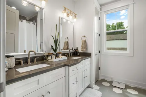 a bathroom with a double vanity sink and a mirror