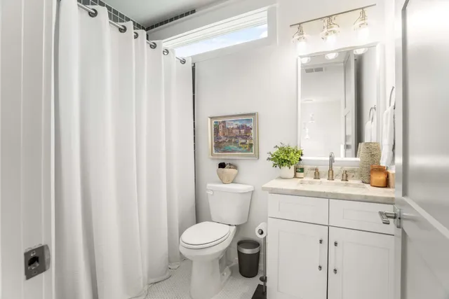 a bathroom with a sink a toilet and shower curtain