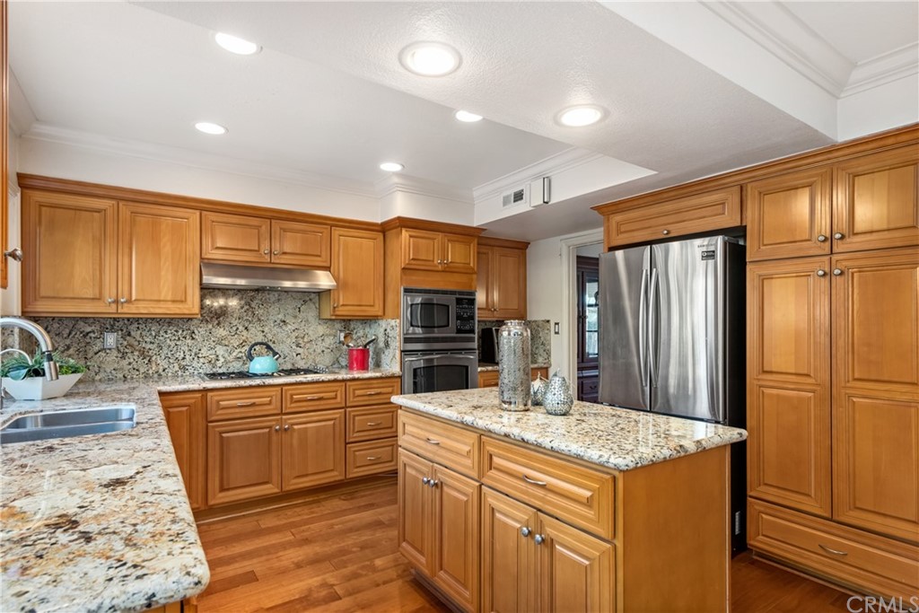 4625 Green Tree Lane Irvine, CA 92612 - Photo 4 of 51 a kitchen with stainless steel appliances granite countertop a sink stove and refrigerator