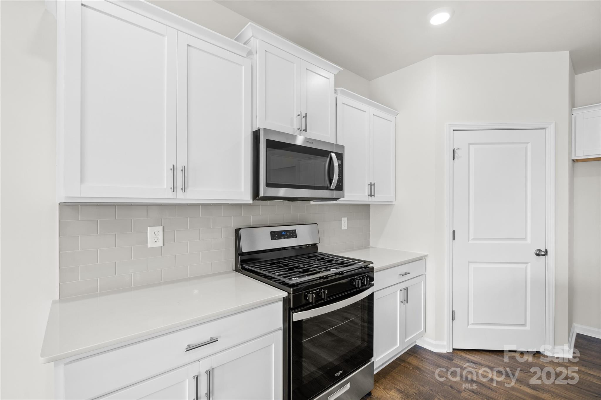 97 Salers Road Fletcher, NC 28732 - Photo 5 of 28 a kitchen with white cabinets and black appliances