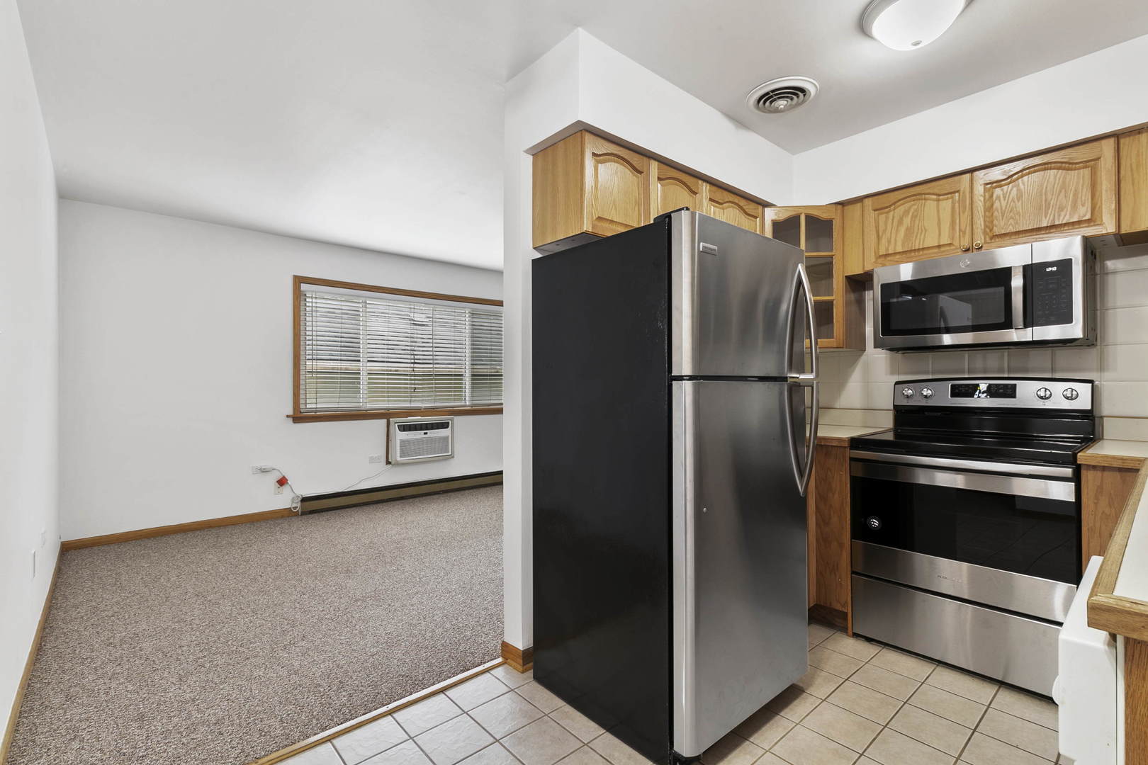 1130 Dunlop Avenue, Unit 2C Forest Park, IL 60130 - Photo 5 of 15 a kitchen with stainless steel appliances a refrigerator and a stove top oven