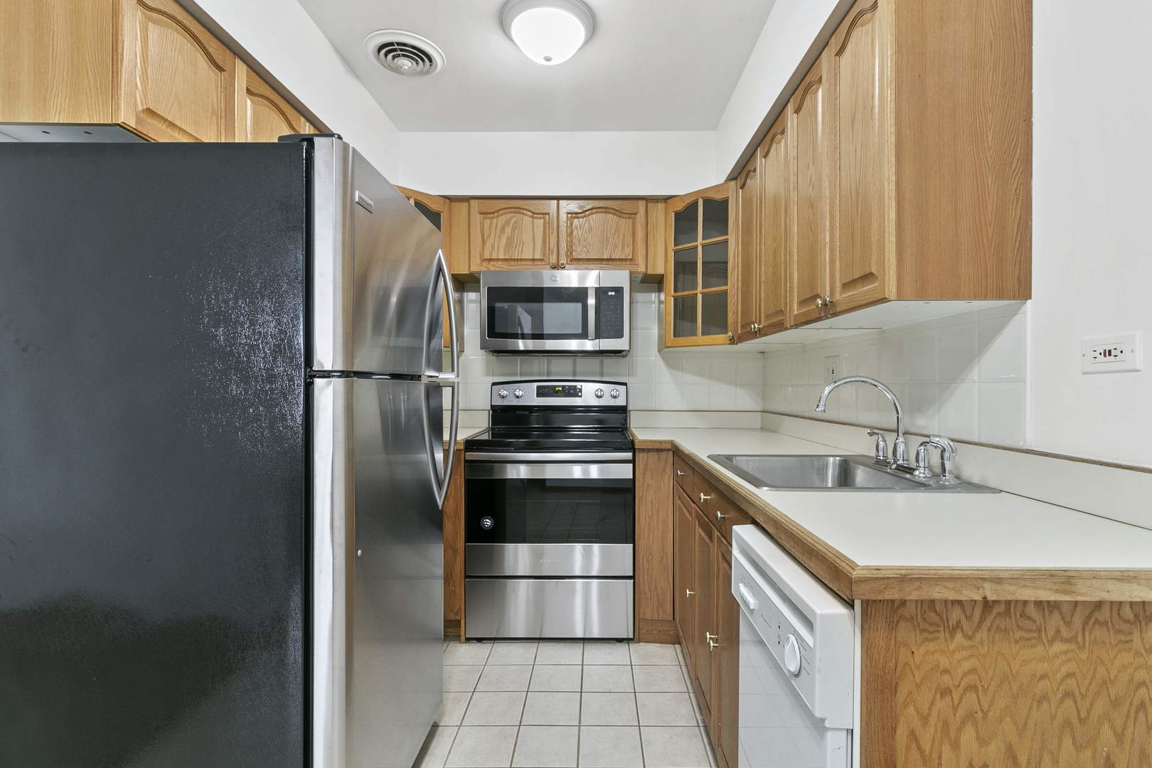 1130 Dunlop Avenue, Unit 2C Forest Park, IL 60130 - Photo 7 of 15 a kitchen with kitchen island a sink appliances and cabinets