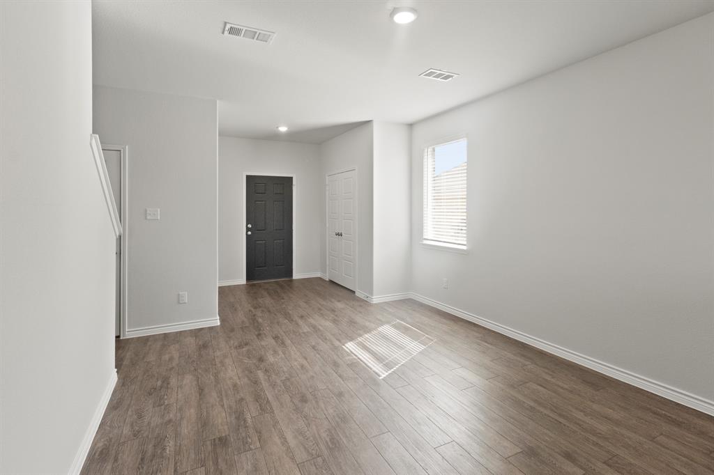 1606 Romans Road Ennis, TX 75119 - Photo 5 of 16 an empty room with wooden floor and windows