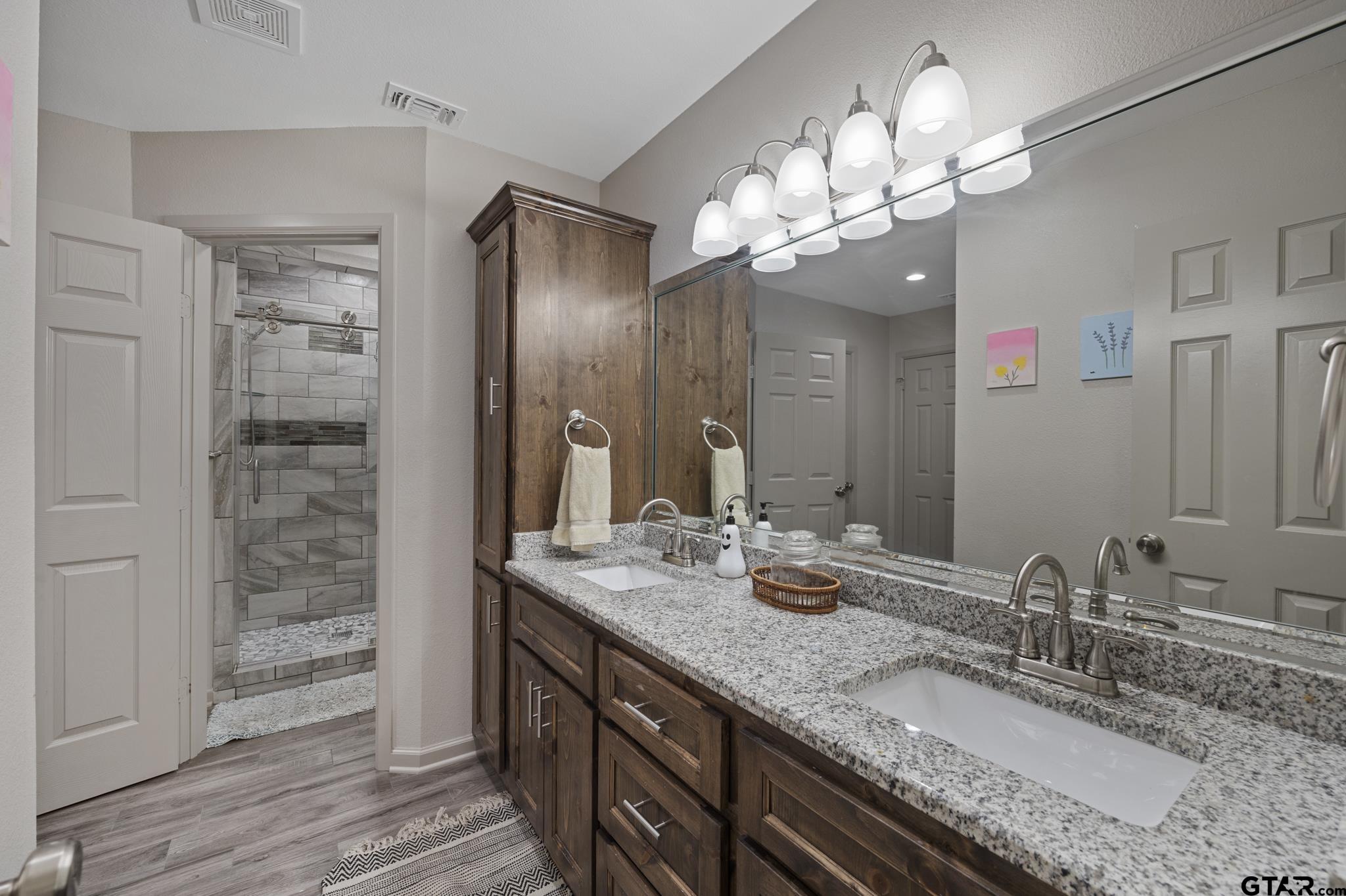 2201 Ridgley Tyler, TX 75703 - Photo 24 of 42 a bathroom with a granite countertop sink a large mirror and a shower