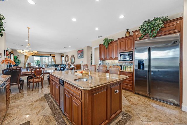 a kitchen with granite countertop a sink a counter top stainless steel appliances and cabinets