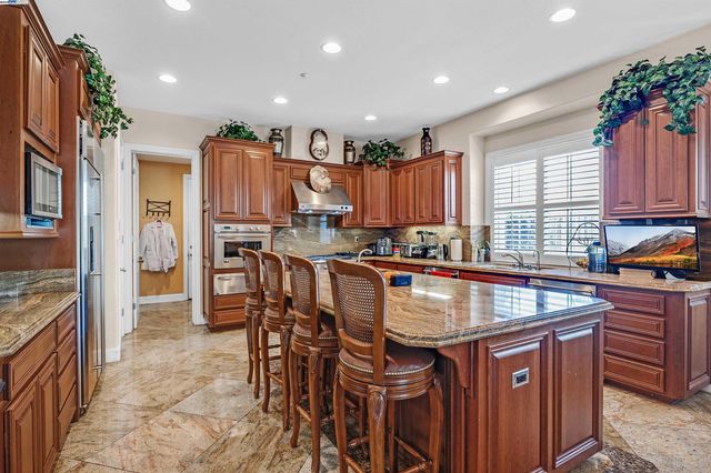 a kitchen with granite countertop a table chairs sink and cabinets