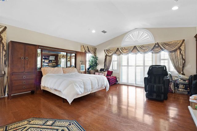 a bedroom with a bed mirror and a window