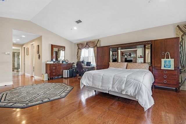 a spacious bedroom with a bed a table and chair