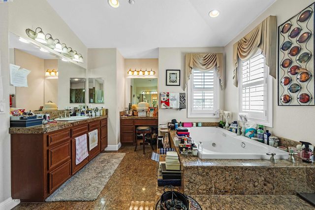 a large spacious bathroom with a granite countertop tub and a large window