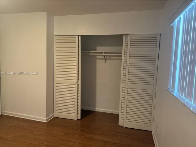 an empty room with wooden floor and closet