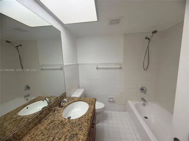 a view of bathroom with a sink and mirror