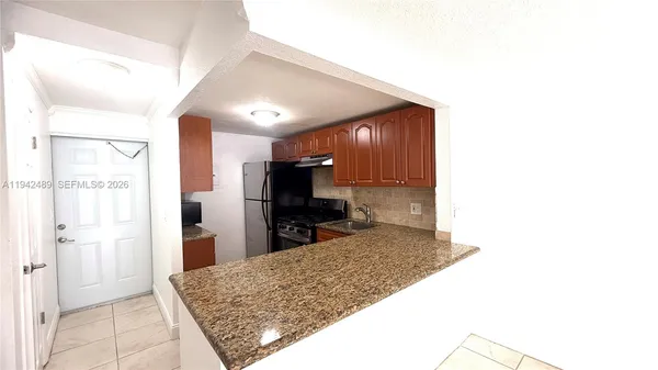 a kitchen with stainless steel appliances kitchen island sink refrigerator and stove