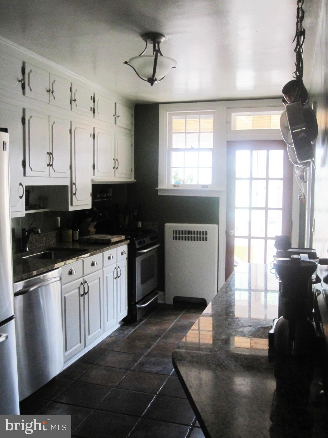 303 Murdock Road Baltimore, MD 21212 - Photo 8 of 25 a kitchen with stainless steel appliances a refrigerator a stove a sink and white cabinets