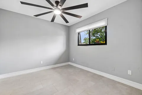 an empty room with window and fan
